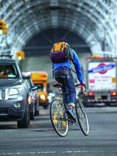 a person riding a bike in the middle of traffic