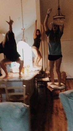 three girls jumping in the air with their hands up and one girl on her knees