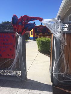 the entrance to a house decorated for halloween with spider - man decorations and plastic covering it