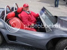 a man sitting in a car that is made to look like it's going down the road