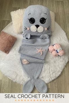 a stuffed animal laying on top of a white rug next to some crocheted toys