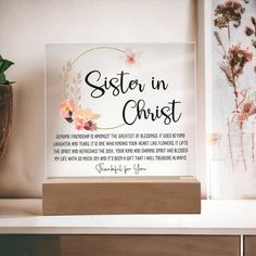 a glass plaque with the words sister in christ on it next to a potted plant