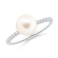 Bringing with it a sense of elegance that transcends time, this pearl solitaire ring in 14K white gold is truly alluring. The diamond studded shank complements the beauty of the peg-set round Freshwater cultured pearl in white. Simple yet captivating, this classic ring is perfect for both your morning and evening looks. White Pearl Ring With Diamond, White Pearl Diamond Ring With Pearl Drop, White Diamond Pearl Drop Ring, Classic White Pearl Ring, Classic White Pearl Ring With Drop Detail, Classic White Pearl Ring With Diamond Accents, White Pearl Rings With Diamond Accents, White Pearl Rings With Brilliant Cut, White Pearl Ring With Brilliant Cut