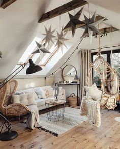 a living room filled with lots of furniture and hanging stars on the ceiling above it