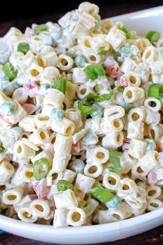 a white bowl filled with macaroni salad on top of a table