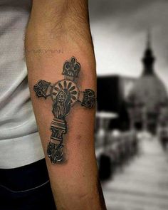 a man with a cross tattoo on his arm