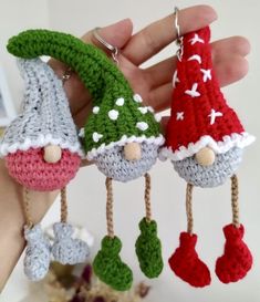 three crocheted gnome ornaments hanging from strings