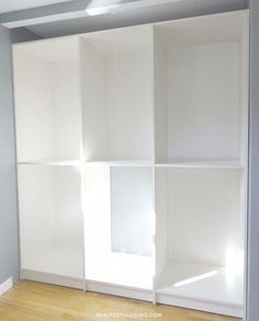 an empty room with white closet doors and hard wood flooring