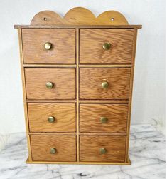 a wooden dresser with six drawers and brass knobs