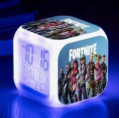 the fortnite alarm clock is lit up with blue light and has an image of fortnites on it