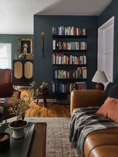 a living room filled with furniture and a bookshelf full of bookcases