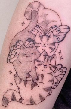 a woman's arm with an image of two cats on it and stars in the background