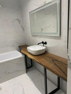 a bathroom with marble walls and flooring has a white bowl sink on the counter