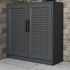 a gray cabinet sitting next to a brick wall