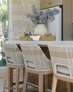 a kitchen table with four chairs and a basket full of food on top of it