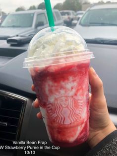 a person holding up a starbucks drink in front of their car with the words vanilla bean frap and strawberry puree in the cup