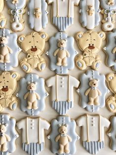 decorated cookies in the shape of teddy bears on a white tablecloth with blue trimmings