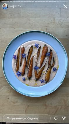 a blue plate topped with carrots on top of a wooden table next to a phone