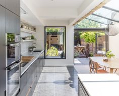 an open kitchen and dining area with glass walls