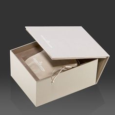 an open white box with two pairs of shoes in it on a black background,