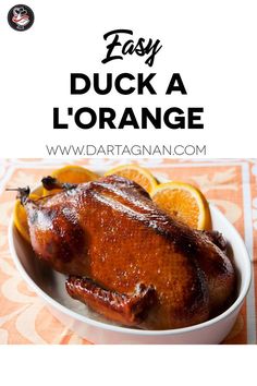 a white bowl filled with sliced oranges and chicken on top of an orange table cloth