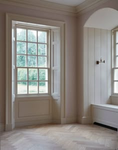 an empty room with two windows and a bench