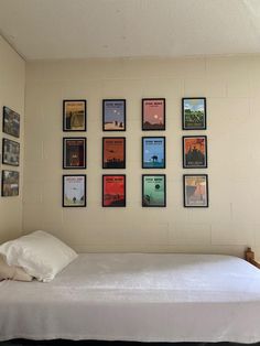 a bed sitting in a bedroom next to a wall with pictures hanging on the walls