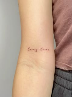 a woman with a small tattoo on her arm that says, love is in the air