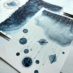 some watercolors are laying on top of paper with space and planets painted on them