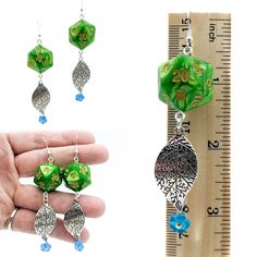 These awesome and beautiful earrings were specially created for the Druid in your RPG group, or any other character who is in tune with the natural world. Three options: Moon: Tree of Life charm with crescent moons hangs below a Chessex Icicle Luminary Borealis D20. These dice appear clear with blue flashes in the light, but have green glow-in-the-dark particles inside. Length is just over 3-1/2 inches overall, and weight is a bit heavier than the others, just over 1/3 ounce (10 grams, the weigh Handmade Green Fantasy Earrings, Green Spiritual Earrings For Gift, Spiritual Green Earrings For Gift, Fantasy Style Drop Earrings For Gift, Fantasy Style Drop Earrings Jewelry Gift, Adjustable Fantasy Earrings For Gift, Adjustable Fantasy Earrings For Gifts, Nickel-free Fantasy Drop Earrings, Fantasy Dangle Jewelry Gift