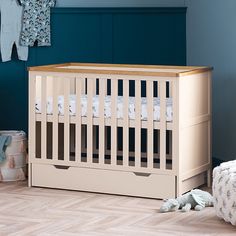 a baby's room with a crib, blanket and toys on the floor