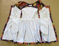 three pieces of white clothing with colorful flowers on them