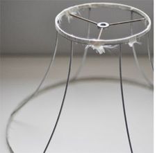 a glass table with a metal frame and white feathers on it