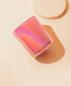 a pink glass sitting on top of a white table next to two circles and the words, iridescent flamingo