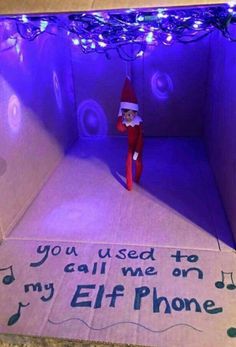 an elf is sitting in a box with music notes on the floor and lights around it