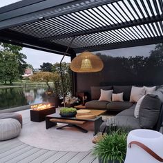 an outdoor living area with couches, tables and fire pit in the middle of it