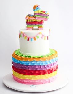 a multi - tiered cake is decorated with colorful ruffles