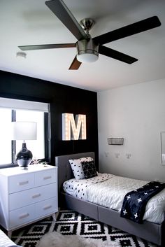 a black and white bedroom with a ceiling fan