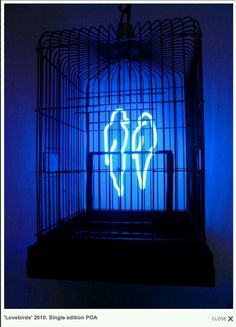 a blue light in a bird cage with the word love on it's side