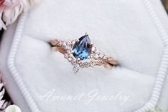 an engagement ring with a blue topaz surrounded by flowers