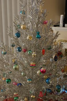 a silver christmas tree with ornaments on it