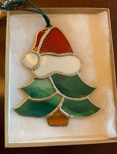 a stained glass christmas tree ornament in a box