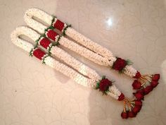 some white and red flowers on top of each other in the middle of a table