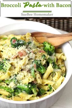 broccoli pasta with bacon and cheese in a white bowl next to a wooden spoon