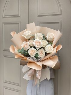 a bouquet of white roses in front of a door