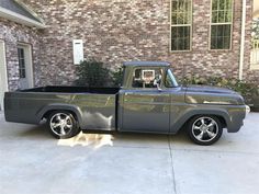 a gray truck parked in front of a brick building