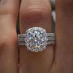 a woman's hand with a diamond ring on top of her finger and the engagement band