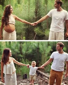 a man and woman holding hands while standing next to a baby in a forest with pine trees