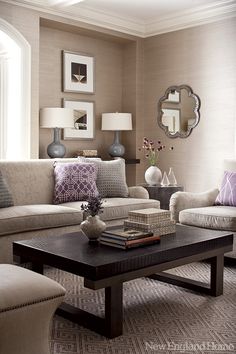 a living room with two couches, a coffee table and pictures on the wall