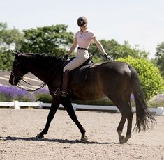 a woman riding on the back of a brown horse